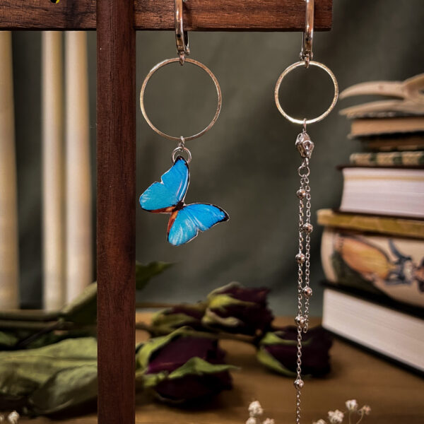 Asymmetrische Schmetterlings-Ohrringe mit blauem Harz-Schmetterling und Kristallstecker